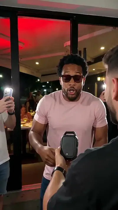 Bulin 47 AI example: a man in sunglasses and a pink T-shirt performs outside a red-lit restaurant as people film him