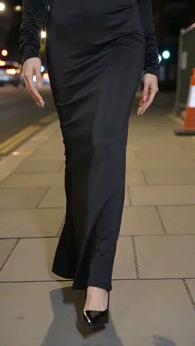 Ramalama AI example: legs in a long black witch dress and heels walk down a city sidewalk at night