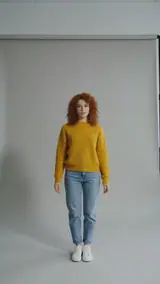 The photo used for this example: a woman with red curls in a yellow sweater and jeans stands in a grey photo studio