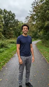 The photo used for this example: a smiling man in a navy t-shirt and grey trousers on a park path